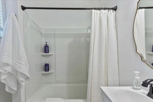 een witte badkamer met een douche en een wastafel bij Close to the Bees Stadium Right off i15 in Salt Lake City