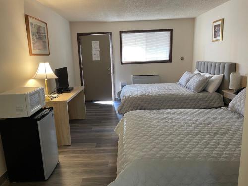a hotel room with two beds and a television at The 22 Hotel in Cremona