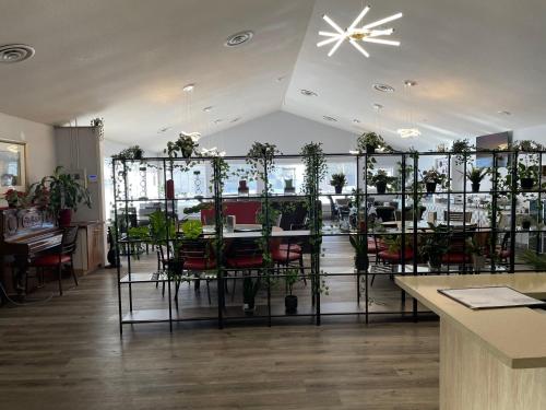 ein Restaurant mit einem Tisch und Stühlen mit Pflanzen in der Unterkunft The 22 Hotel in Cremona