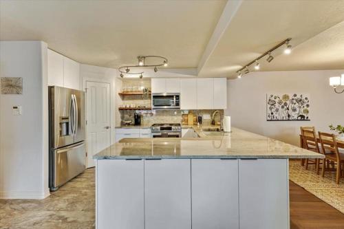 una gran cocina con armarios blancos y una gran isla en Cozy Home Close to the Slopes en Sandy