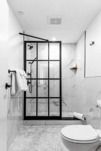 a white bathroom with a shower and a toilet at The Phenix Historic Hotel, King Bed, Room # 302 in Bangor