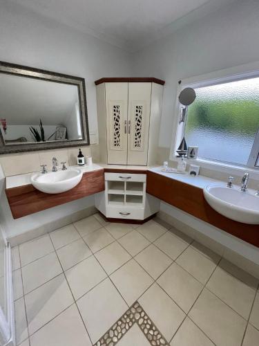 a bathroom with two sinks and a large window at Watermill Beach House Estate in Kingston