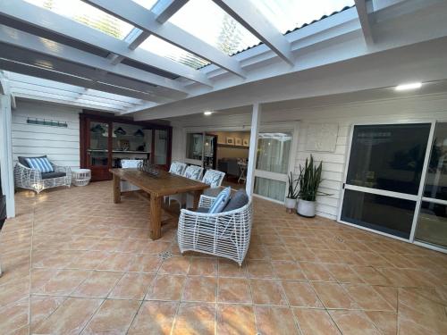 a conservatory with a table and chairs on a patio at Watermill Beach House Estate in Kingston