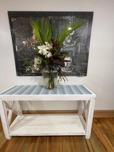 a vase of flowers sitting on a white table at Watermill Beach House Estate in Kingston
