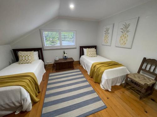 a room with two beds and a chair in it at Watermill Beach House Estate in Kingston