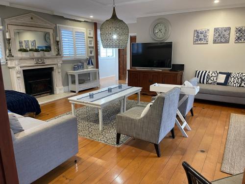a living room with a couch and a tv at Watermill Beach House Estate in Kingston