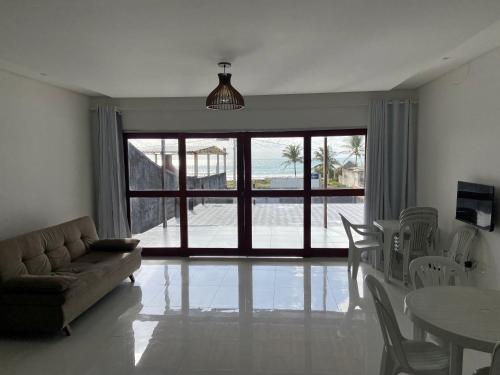 uma sala de estar com um sofá e uma mesa com cadeiras em Casa de praia Enseadas do corais - 20 metros da praia em Cabo de Santo Agostinho