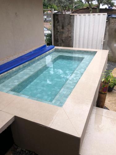 uma piscina numa casa com piso em azulejo em Reges Hostel em Alto Paraíso de Goiás