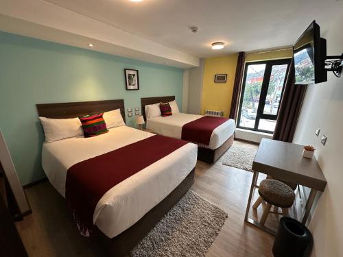 a hotel room with two beds and a window at CASA CRISTOBAL Centenario in Cusco