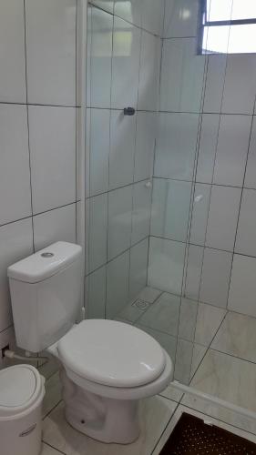 ein weißes Bad mit einem WC und einer Dusche in der Unterkunft Quartos em Ametista do Sul in Ametista do Sul