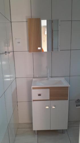 a white bathroom with a sink and a mirror at Quartos em Ametista do Sul in Ametista do Sul