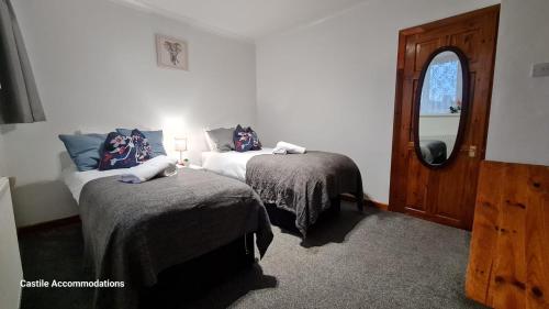 1 dormitorio con 2 camas, ventana y puerta en Flourish House, en Kent