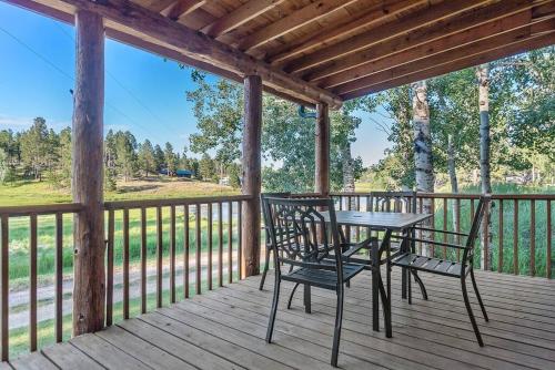 a porch with a table and chairs on a deck at Mountain View Gem BHBungalows #2 in Custer