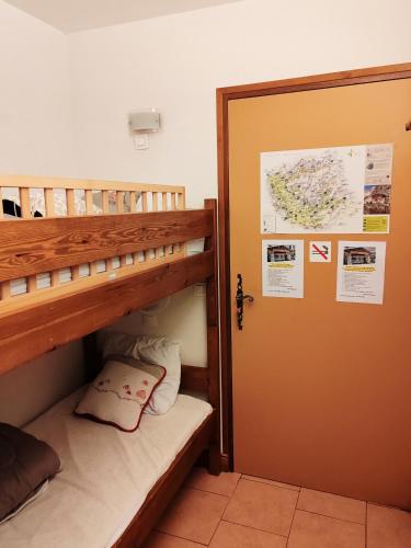 Cette chambre comprend 2 lits superposés et une porte. dans l'établissement Joli appart 4 personnes au pied des pistes balcon, à Orcières