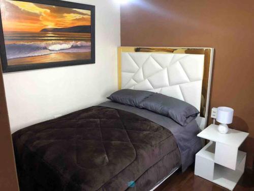 1 dormitorio con 1 cama y una pintura en la pared en Departamento 2 habitaciones, en Cochabamba