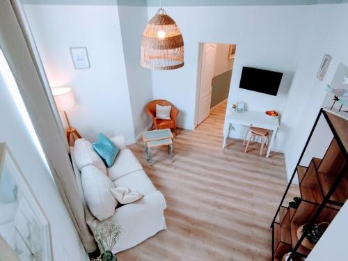un salon avec un canapé blanc et une télévision dans l'établissement Plage & Confort Appartement 3 pièces Parking clim et wifi, à Antibes