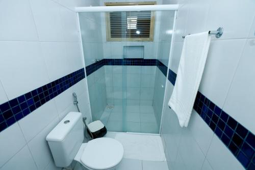 a bathroom with a toilet and a glass shower at Pousada Oásis do Cariri in Juazeiro do Norte