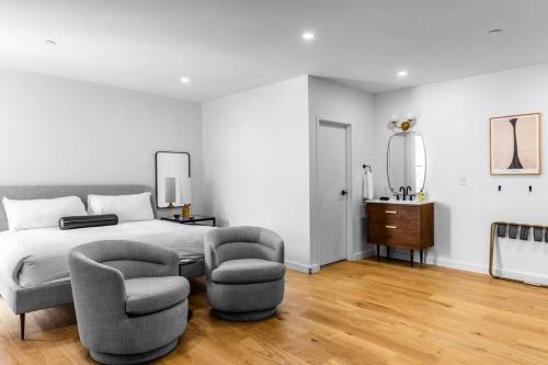 Un dormitorio con una cama y dos sillas y un espejo. en Historic DTWN Hotel, The Phenix, King Bed, Room # 303, en Bangor