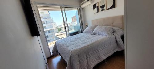 a bedroom with a bed and a large window at Punta Carretas, Garaje, Piscina, Gimnasio in Montevideo