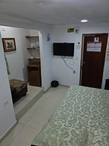 1 dormitorio con 1 cama y TV de pantalla plana en El Hostal By Pochet, en San Andrés