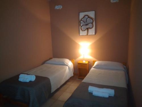 a hotel room with two beds and a lamp at Departamentos la Merced in San Nicolás de los Arroyos