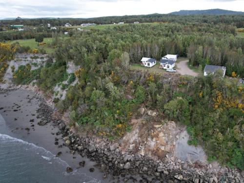 an aerial view of two cottages on an island near the water at Cabañas Bosquemar 1 in Queilén