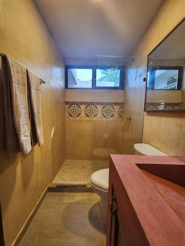 a small bathroom with a toilet and a shower at Modern loft with AC near Paseo Montejo - El Rosal in Mérida