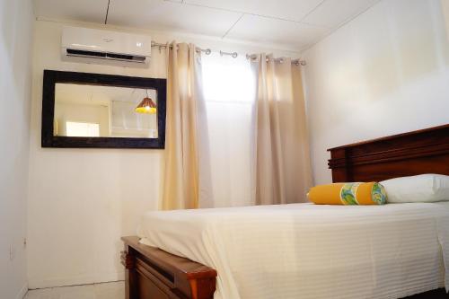 um quarto com uma cama com um espelho e uma janela em Casita Marlín Quepos em Quepos