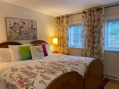 a bedroom with a large bed with flowers on it at Belle Maison Auprès De La Mer in Sidney