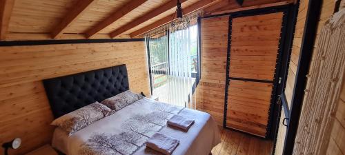 a bedroom with a bed in a room with a window at Cabaña Starka & Jacuzzi in Marinilla