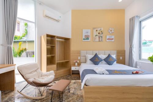 a bedroom with a bed and a chair at Ruby Villa in Vung Tau