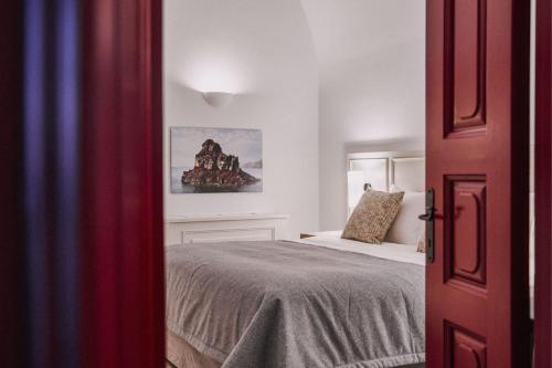 a bedroom with a bed and a painting on the wall at Vedema, a Luxury Collection Resort, Santorini in Megalokhori