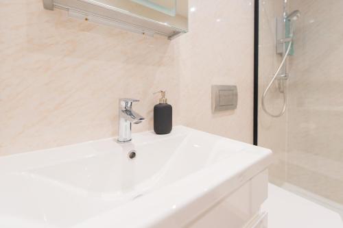 y baño blanco con lavabo y ducha. en Cosy 2 Bedroom Flat in Lake District en Kendal