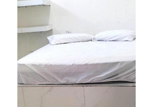 a bed with white sheets and pillows on it at Hostel Summer Praia do Sol in João Pessoa
