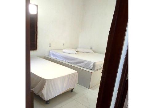 a small room with two beds and a mirror at Hostel Summer Praia do Sol in João Pessoa