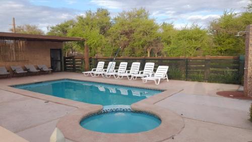 una piscina con tumbonas y una piscina en Cabañas el Chañar, en San Pedro de Atacama