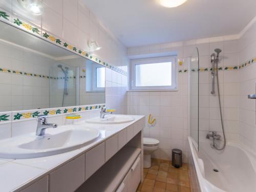 une salle de bain avec deux lavabos et une baignoire et des toilettes dans l'établissement Gîte rénové éco-responsable près de la forêt et des lacs, idéal pour la détente et la nature - FR-1-306-868, à Joué-sur-Erdre