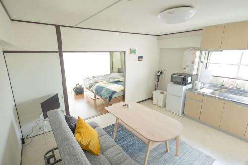 a living room with a couch and a table and a bed at NOBEYAMA WIND in Tokyo
