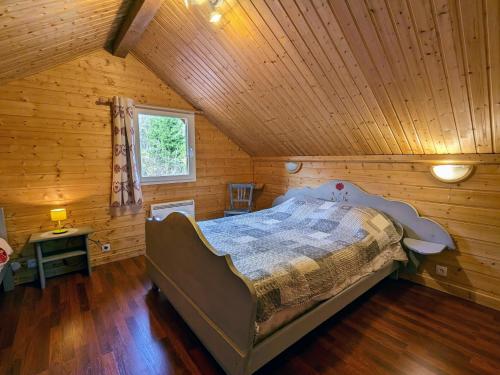 een slaapkamer met een bed in een houten hut bij Gîte Vagney, 4 pièces, 6 personnes - FR-1-589-283 in Vagney