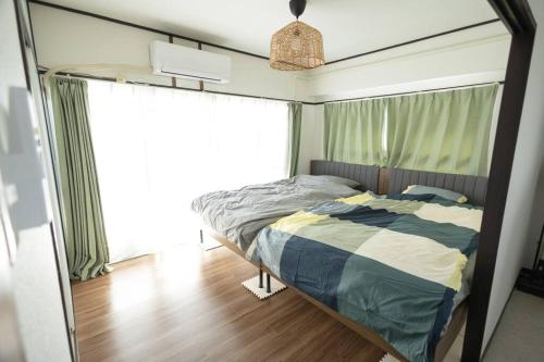 een slaapkamer met een bed en een groot raam bij NOBEYAMA WIND in Tokyo