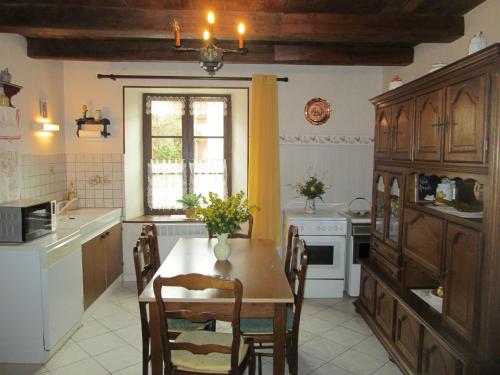 une cuisine avec une table et des chaises et une fenêtre dans l'établissement Maison cosy avec terrasse, 3 chambres, wifi, animaux acceptés, idéal pour familles en Meuse - FR-1-585-2, à Bréhéville