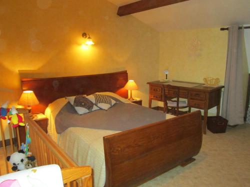 a bedroom with a large bed and a desk and a desk at Maison cosy avec terrasse, 3 chambres, wifi, animaux acceptés, idéal pour familles en Meuse - FR-1-585-2 in Bréhéville