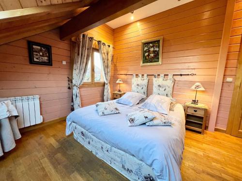 ein Schlafzimmer mit einem Bett in einem Zimmer mit Holzwänden in der Unterkunft Gîte Gérardmer, 5 pièces, 8 personnes - FR-1-589-114 in Gérardmer