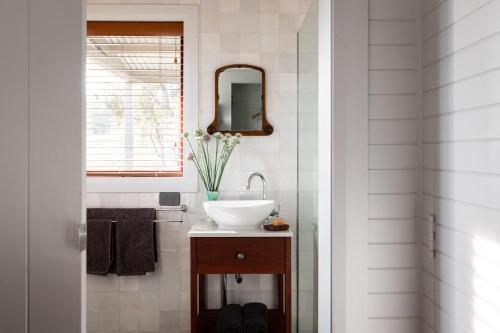 a bathroom with a sink and a mirror at Kestrel Nest EcoHut in Mount Adrah