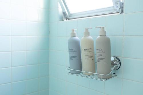 three bottles of shampoo on a rack in a bathroom at NOBEYAMA WIND in Tokyo