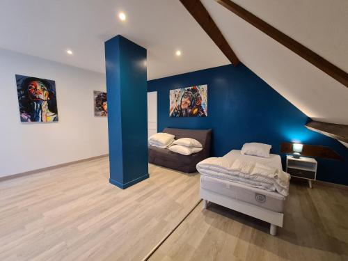 Cette chambre comprend 2 lits et un mur bleu. dans l'établissement Grande Maison au Bord d'un Lac avec Spa, Jardin Clôturé et Proche du ZooParc de Beauval - FR-1-591-336, à Luçay-le-Mâle