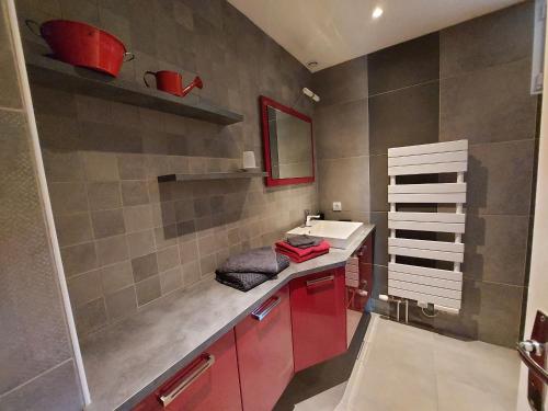 baño con armarios rojos y lavabo blanco en Gîte Saint-Pierre-sur-Orthe, 4 pièces, 7 personnes - FR-1-600-185, en Saint-Pierre-sur-Orthe