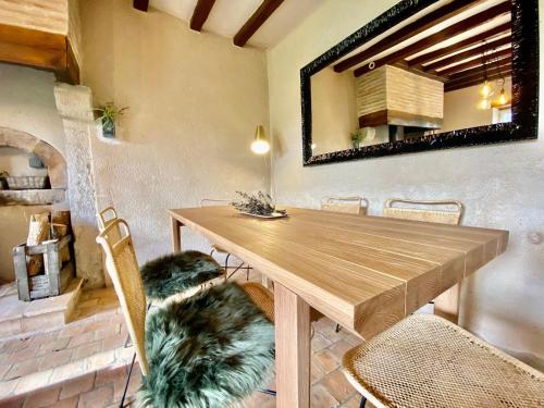 - une table à manger avec des chaises et un miroir dans l'établissement Gîte charmant proche du Mans et de la Flèche, tout confort, jardin clos, garage, animaux bienvenus - FR-1-410-313, à Courcelles-la-Forêt