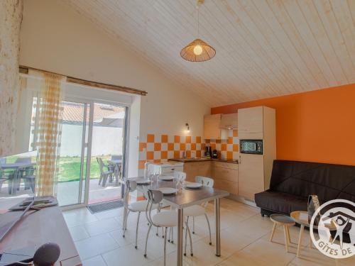 une cuisine et un salon avec une table et un canapé dans l'établissement Gîte champêtre proche Puy du Fou avec terrasse, parking privé et tout inclus ! - FR-1-622-31, à Saint-Christophe-du-Bois