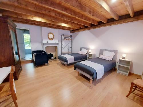 Großes Zimmer mit 2 Betten und einem Kamin in der Unterkunft Gîte Saint-Poix, 5 pièces, 11 personnes - FR-1-600-212 
